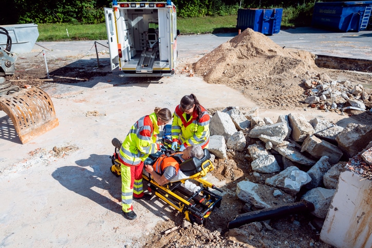 Emergency doctor and paramedic taking care of man on site of accident