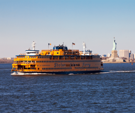 Staten Island Personal Injury Lawyers. Image of Staten Island Ferry on water passing the statue of liberty.
